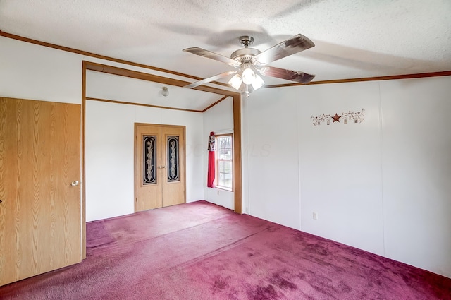 carpeted empty room featuring crown molding, vaulted ceiling, ceiling fan, and a textured ceiling