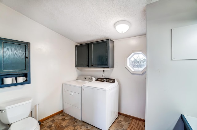 washroom featuring laundry area, baseboards, stone finish flooring, a textured ceiling, and separate washer and dryer