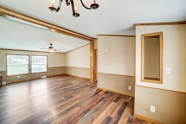 interior space with a textured ceiling, wainscoting, wood finished floors, and crown molding