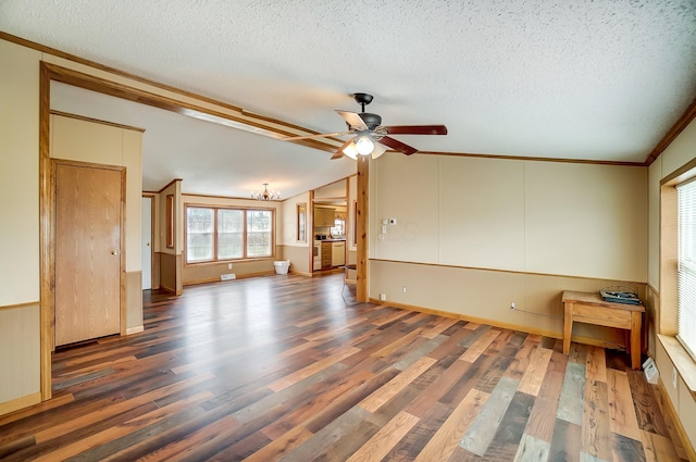 spare room with a textured ceiling, vaulted ceiling, and wood finished floors