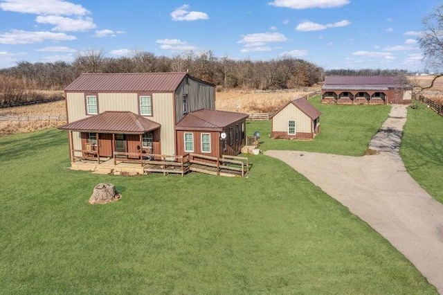 back of property featuring metal roof, a yard, and driveway
