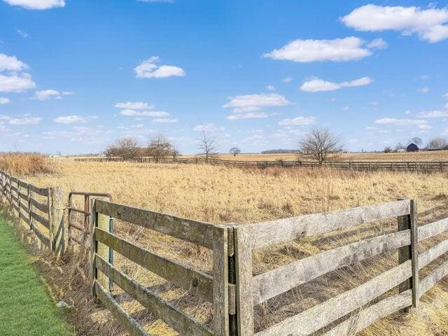 view of yard featuring a rural view and fence