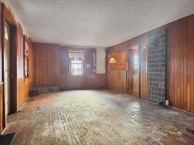 spare room featuring wood walls and a textured ceiling