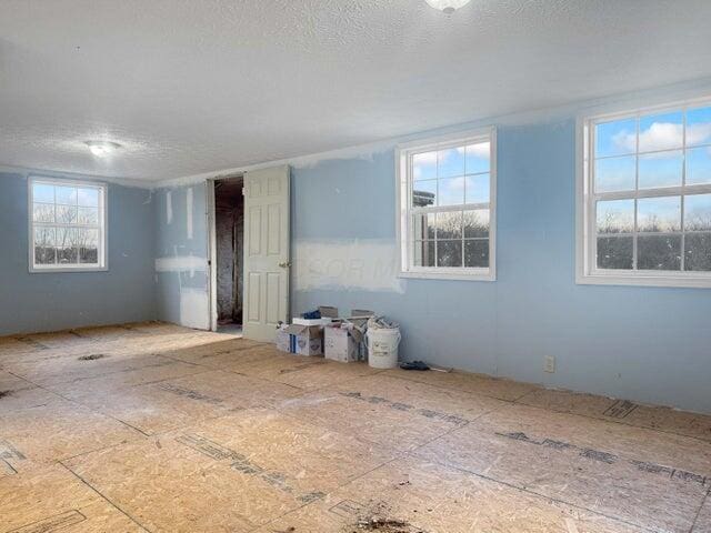 unfurnished room with a textured ceiling