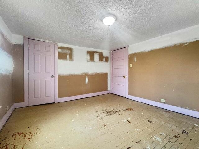 empty room with a textured ceiling and baseboards
