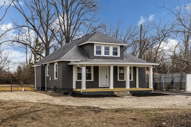 view of front of property featuring fence, a porch, and roof with shingles