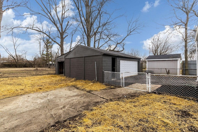 detached garage featuring fence and a gate