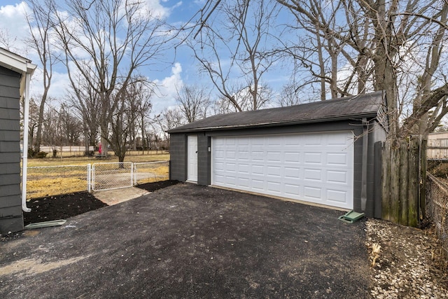 detached garage featuring a gate and fence