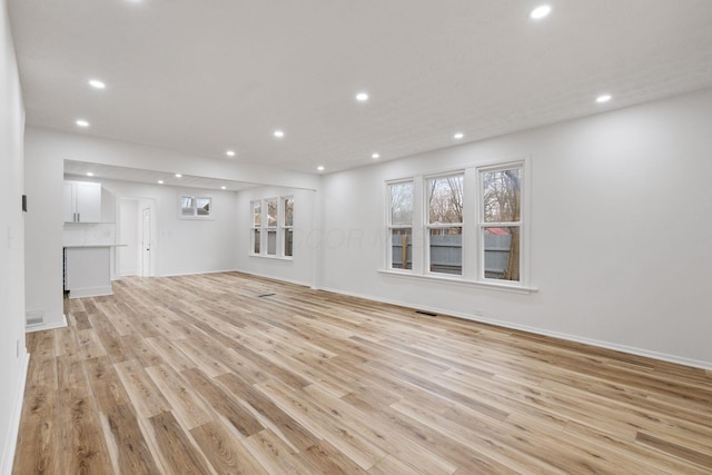 unfurnished living room with light wood-style flooring, baseboards, and recessed lighting