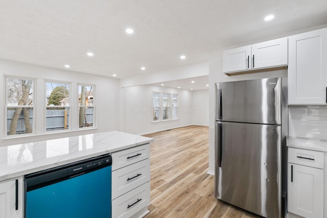 kitchen featuring white cabinets, dishwashing machine, light wood finished floors, and freestanding refrigerator