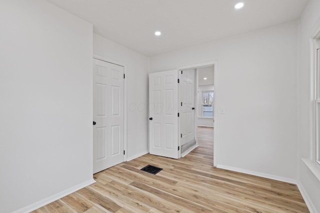 empty room with light wood-style floors, recessed lighting, and baseboards