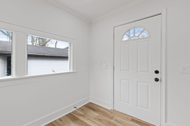 entryway with plenty of natural light, light wood-style flooring, baseboards, and ornamental molding