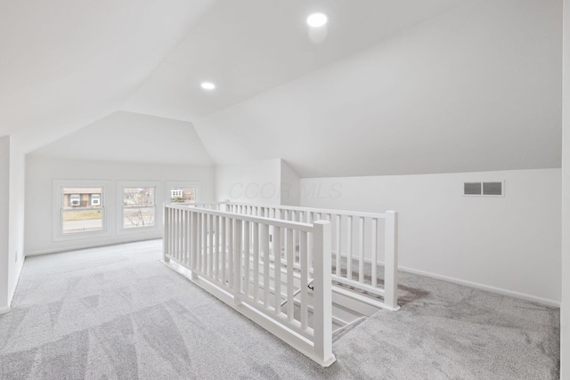 bonus room featuring carpet floors, baseboards, visible vents, and lofted ceiling