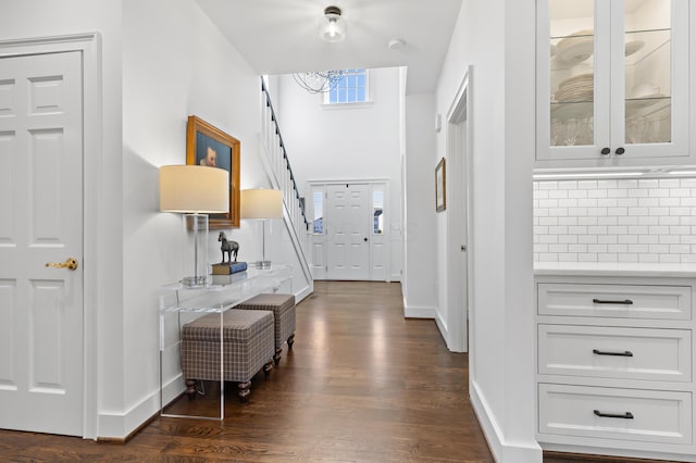 entryway featuring dark wood-style floors, stairs, and baseboards