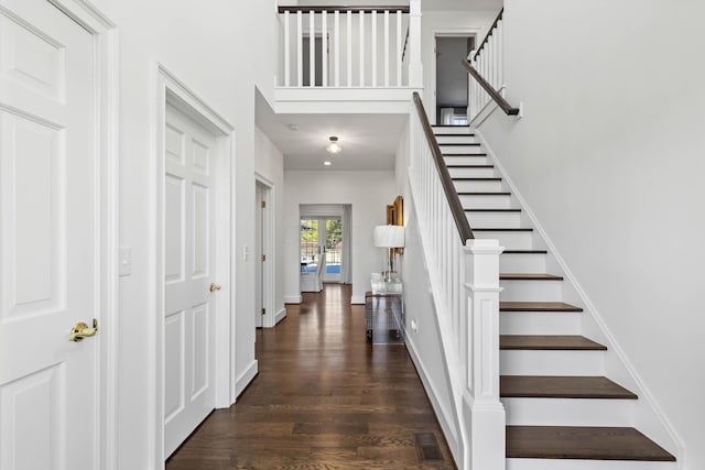 foyer featuring stairway, baseboards, visible vents, and wood finished floors