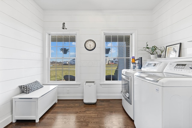 clothes washing area featuring washer and dryer, baseboards, dark wood-type flooring, and laundry area