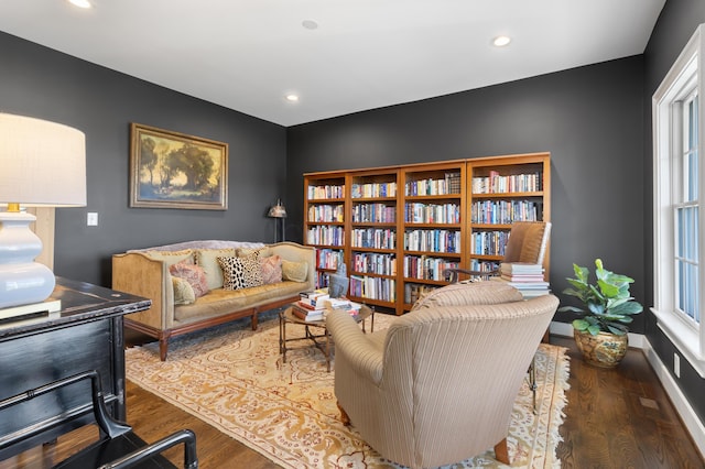living area featuring recessed lighting, wood finished floors, baseboards, and a healthy amount of sunlight