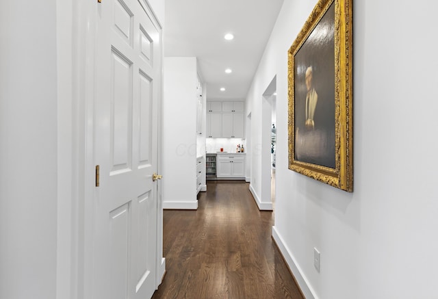 corridor with dark wood-style floors, recessed lighting, and baseboards