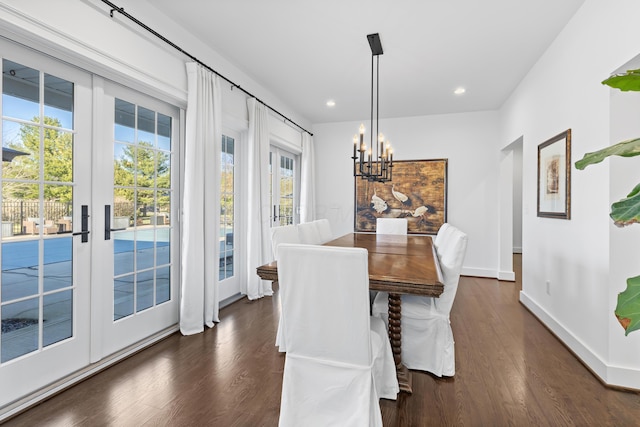 dining space featuring dark wood-type flooring, recessed lighting, baseboards, and a chandelier