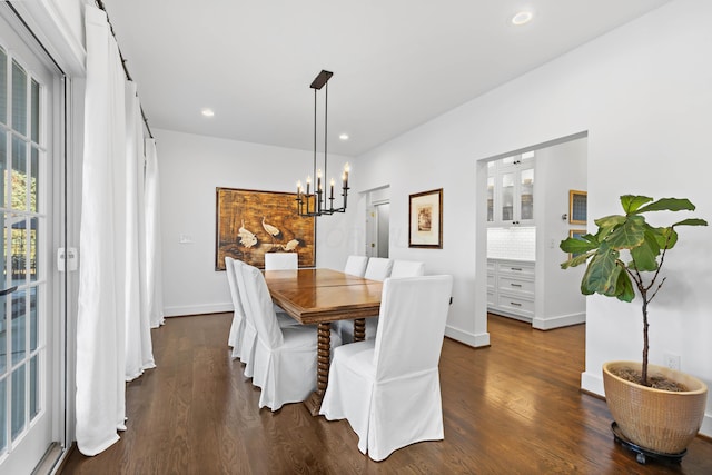 dining space with baseboards, dark wood finished floors, an inviting chandelier, recessed lighting, and a wealth of natural light