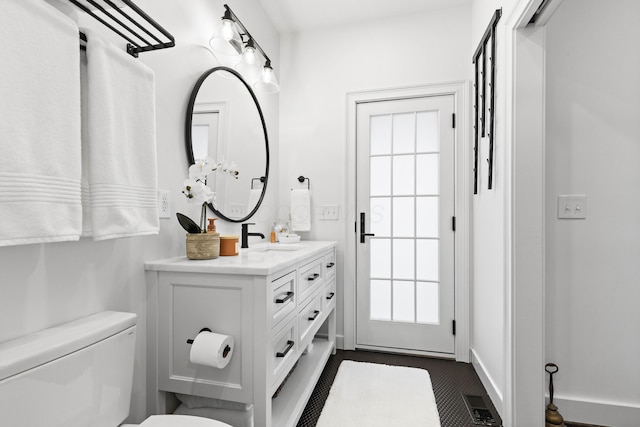 bathroom with visible vents, toilet, a healthy amount of sunlight, and vanity