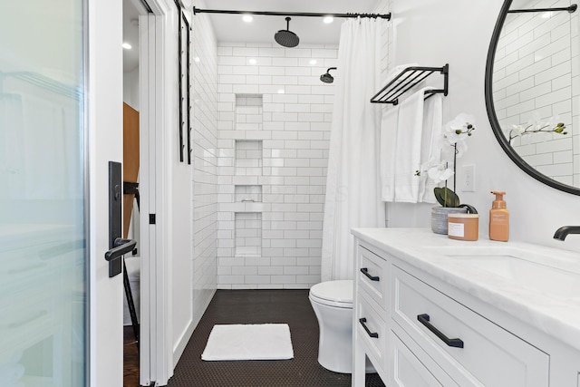 full bathroom with vanity, tile patterned floors, toilet, and tiled shower