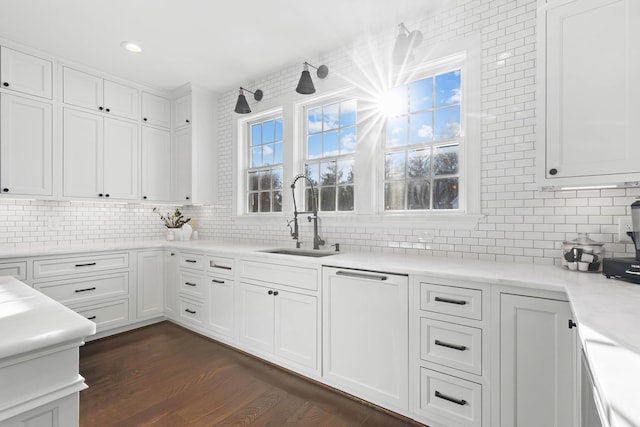 kitchen with dark wood-style floors, white cabinets, backsplash, and a sink