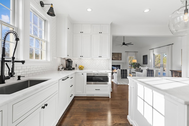 kitchen featuring a sink, backsplash, dark wood-style floors, and recessed lighting