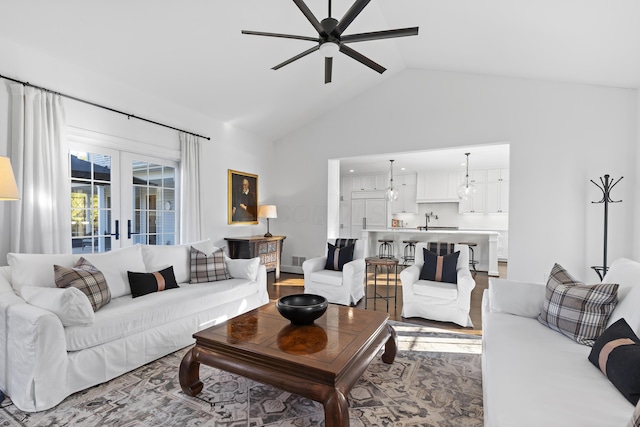 living area with wood finished floors, ceiling fan, and vaulted ceiling