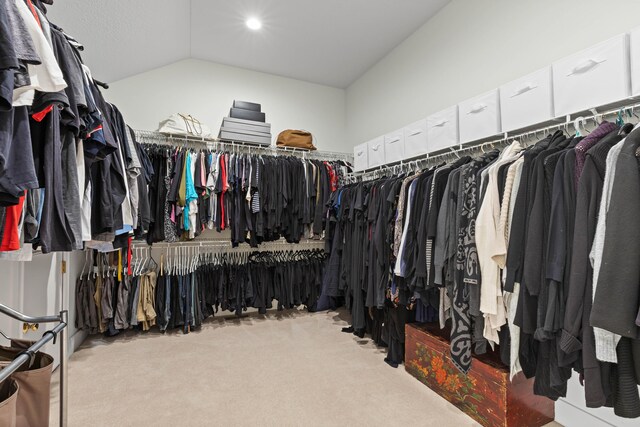 walk in closet with carpet floors and vaulted ceiling