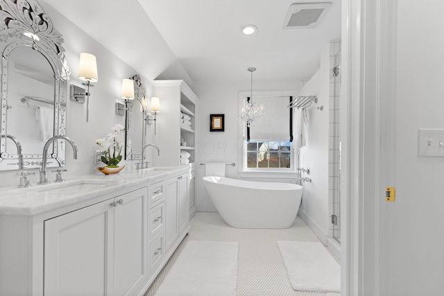 bathroom with tile patterned flooring, a freestanding bath, visible vents, and a sink