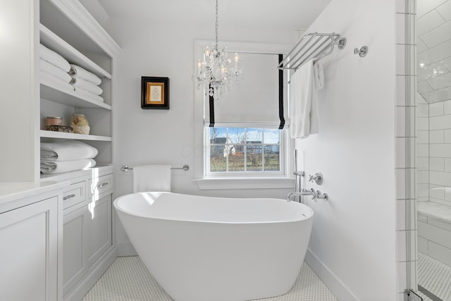 bathroom with baseboards, a chandelier, tiled shower, a freestanding tub, and vanity