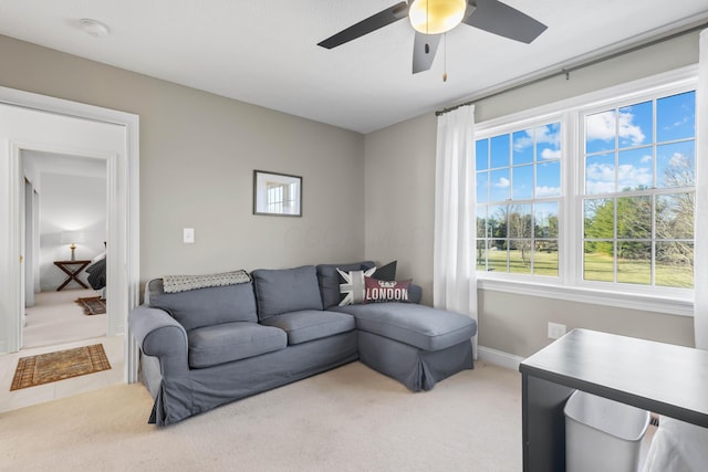 carpeted living room featuring baseboards and a ceiling fan