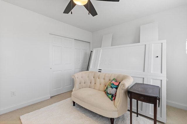 sitting room featuring carpet flooring, baseboards, and ceiling fan