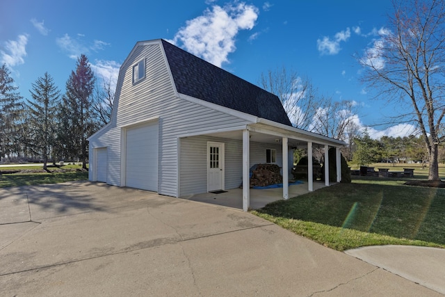 view of side of property with a gambrel roof, a lawn, roof with shingles, and a detached garage