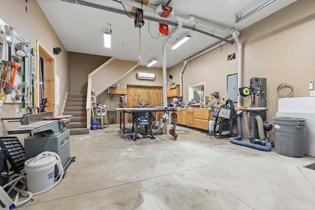 garage with a workshop area, a wall mounted air conditioner, and a garage door opener