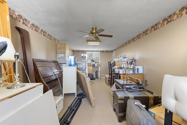 carpeted office with a textured ceiling and a ceiling fan