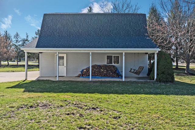 rear view of property with a yard and a shingled roof