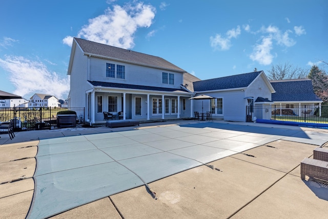 rear view of house featuring a patio, fence, and a fenced in pool