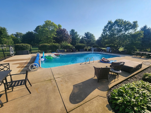 community pool with a patio and fence