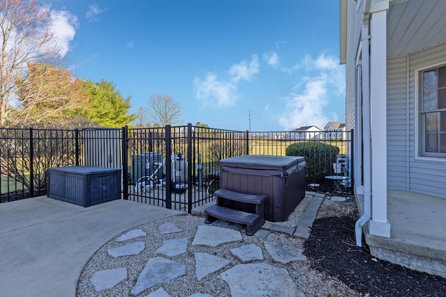 view of patio featuring fence and a hot tub