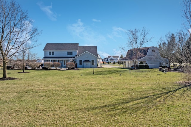 back of property featuring a barn, a yard, and an outbuilding