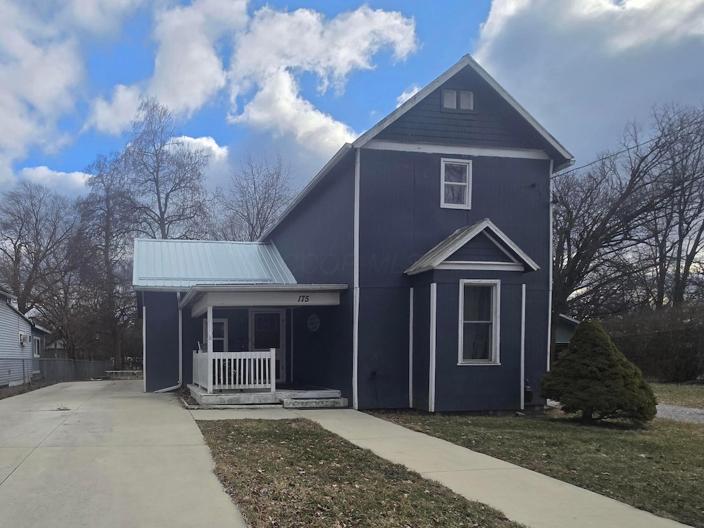 traditional home with covered porch and metal roof