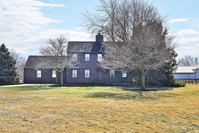 rear view of property with a lawn and a chimney