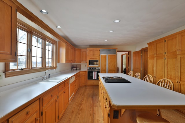8871 Patterson Rd, Hilliard, OH 43026 - kitchen with black appliances, a center island, recessed lighting, light countertops, and light wood-style floors