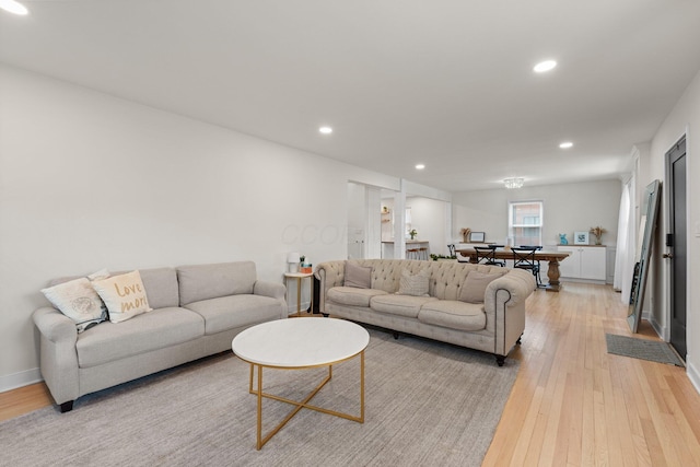 living room featuring baseboards, recessed lighting, and light wood-style floors