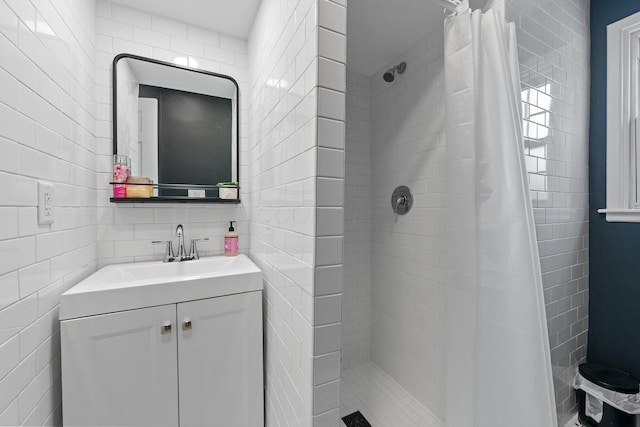 full bathroom with tasteful backsplash, a stall shower, vanity, and tile walls