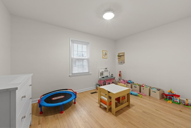 rec room featuring wood-type flooring, visible vents, and baseboards