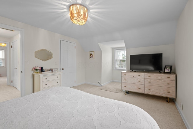 bedroom with lofted ceiling, baseboards, and light colored carpet