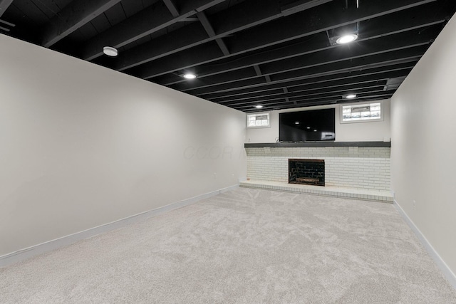 below grade area featuring a fireplace, baseboards, and carpet flooring